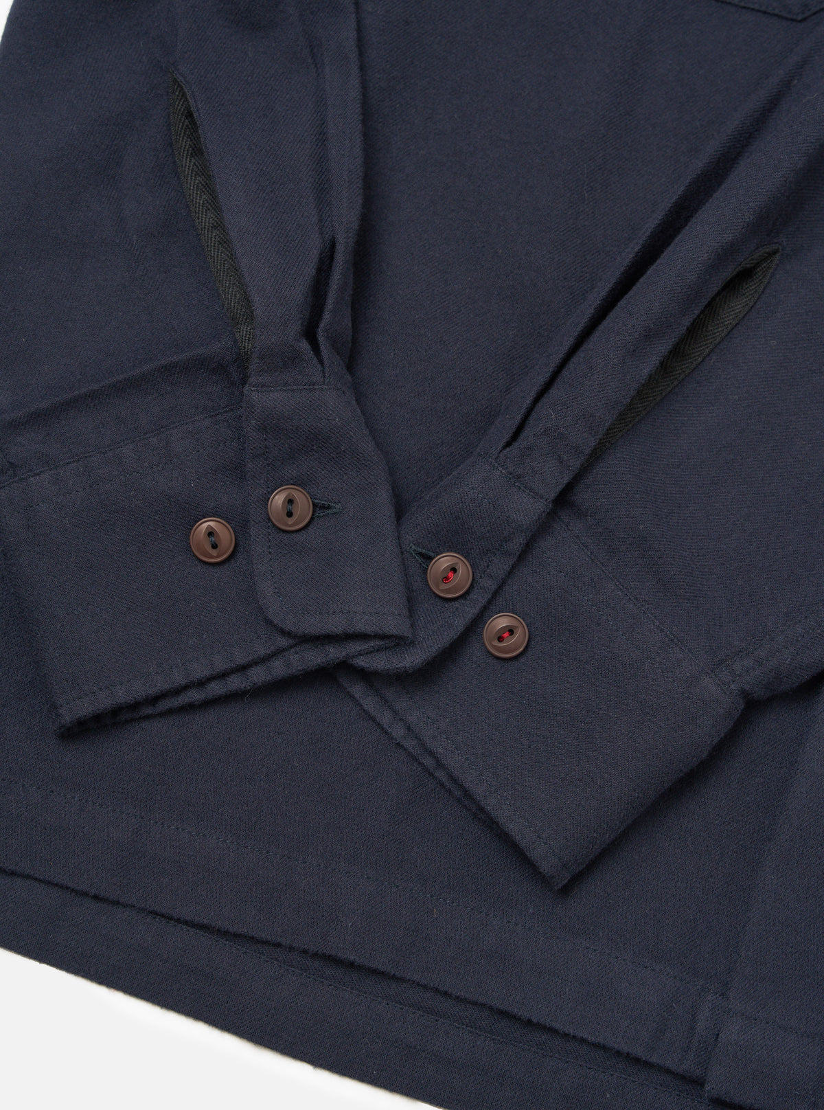 Close-up of the Dark Navy Sid Flannel CPO Shirt on a white surface. Shows the flannel texture, button details, and sleeve construction.