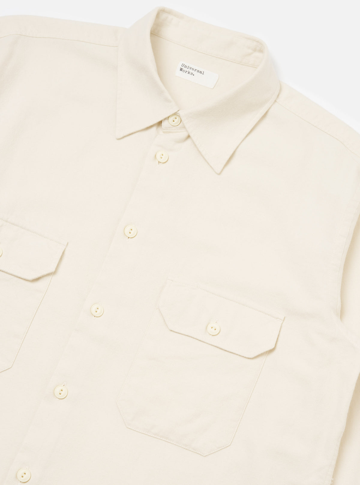 Close-up of the Ecru Sid Flannel CPO Shirt on a white background. The shirt is ecru-colored and made of flannel. It has a classic fit with a button-down front and two chest pockets.