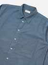 Close-up of the Blue Brushed Marl Twill Square Pocket Shirt on a white background. The shirt is blue with a square pocket and white buttons.