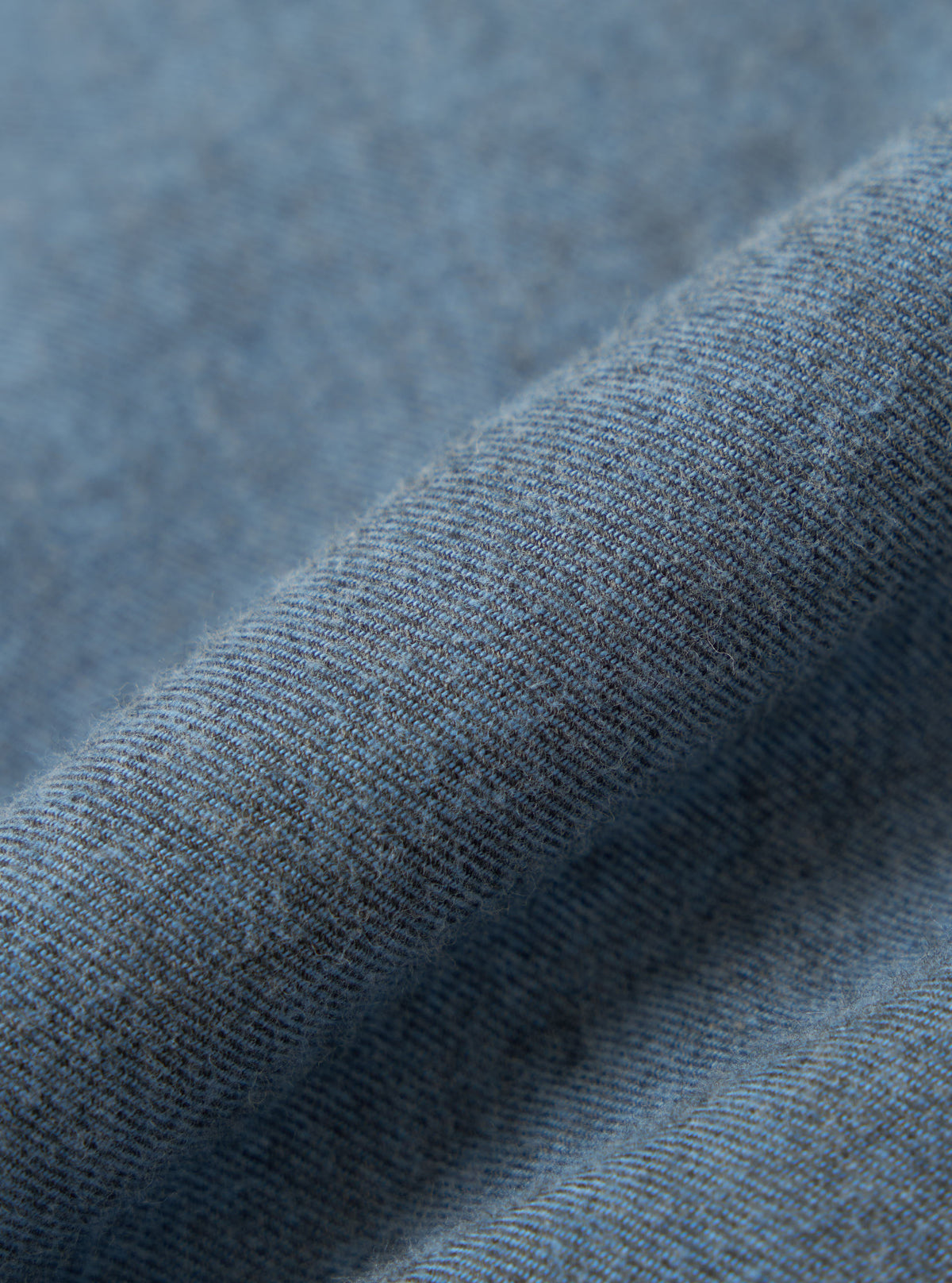 Close-up of the Blue Brushed Marl Twill Square Pocket Shirt fabric. The twill weave is visible, showing the texture and color variations of the shirt.