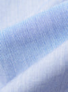 Close-up of the Blue Classic Stripe Lazy Day Shirt fabric. Light blue and white stripes create a soft, textured look. The material is neatly folded on a plain surface.