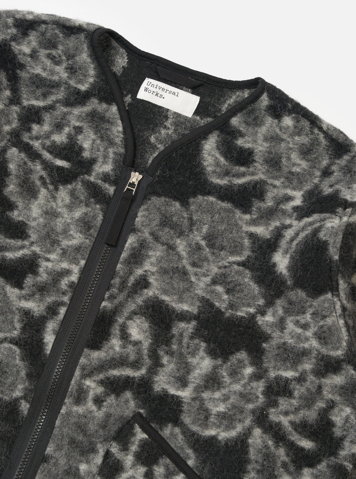 Close-up of the Charcoal Flower Fleece Zip Liner Jacket on a white background. The jacket has a black and gray floral pattern and a black zipper.