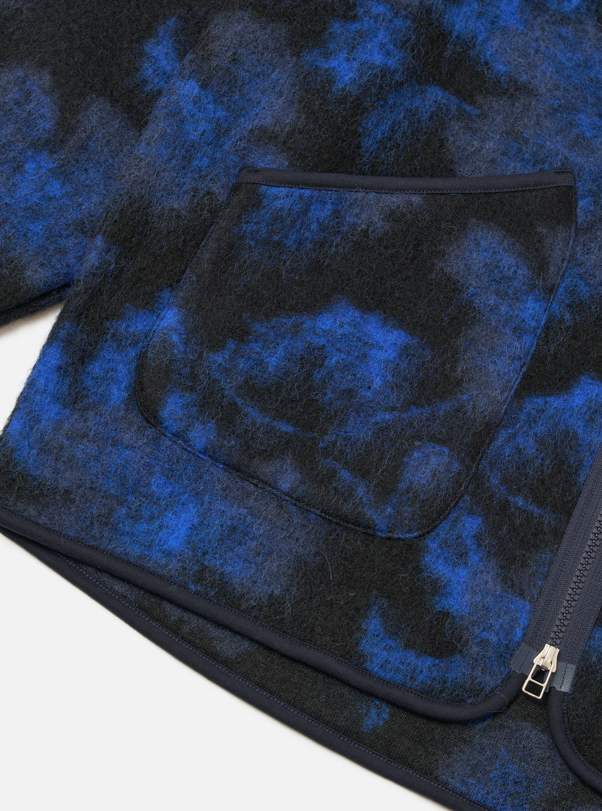 Close-up of the Blue Flower Fleece Zip Liner Jacket showing the blue and black fleece material, pocket detail, and zipper on a white background.