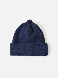 Close-up of a Navy Alpaca/British Wool Bobble Hat on a white background. The knitted hat has a folded brim and a bobble on top.