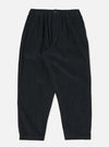 Studio shot of the Black Cat Cord Pleated Track Pant. The black corduroy pants are on a white background. The pants have a relaxed fit.