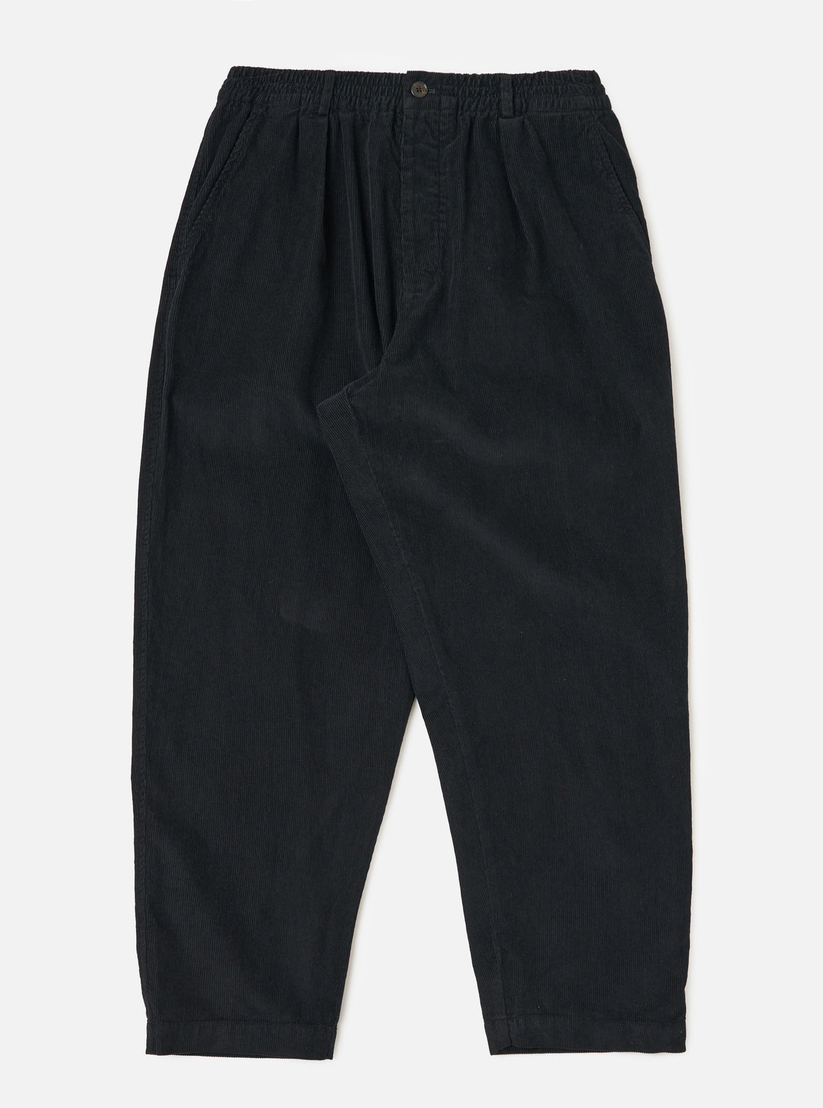 Studio shot of the Black Cat Cord Pleated Track Pant. The black corduroy pants are on a white background. The pants have a relaxed fit.