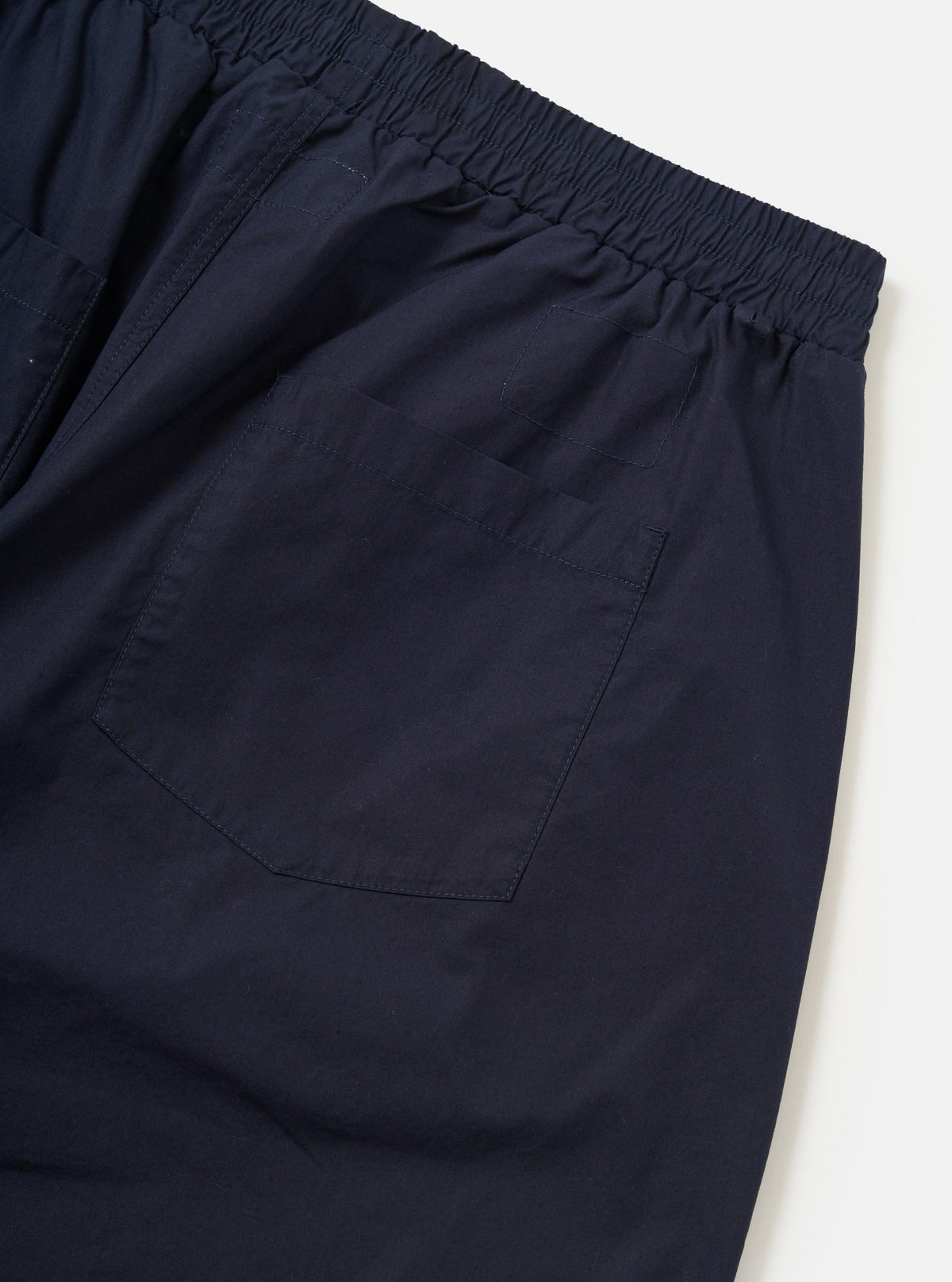 A pair of Navy Paper Touch Cotton Vacation Shorts is shown from the back, laid flat against a solid white background. The image highlights the two rear patch pockets and the elasticated waistband.