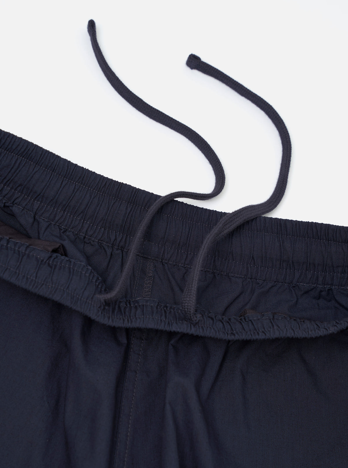 A pair of navy paper touch cotton vacation shorts is shown from a rear perspective, laid flat against a plain white background. The image highlights the two rear patch pockets and the elasticated waistband of the dark blue garment.