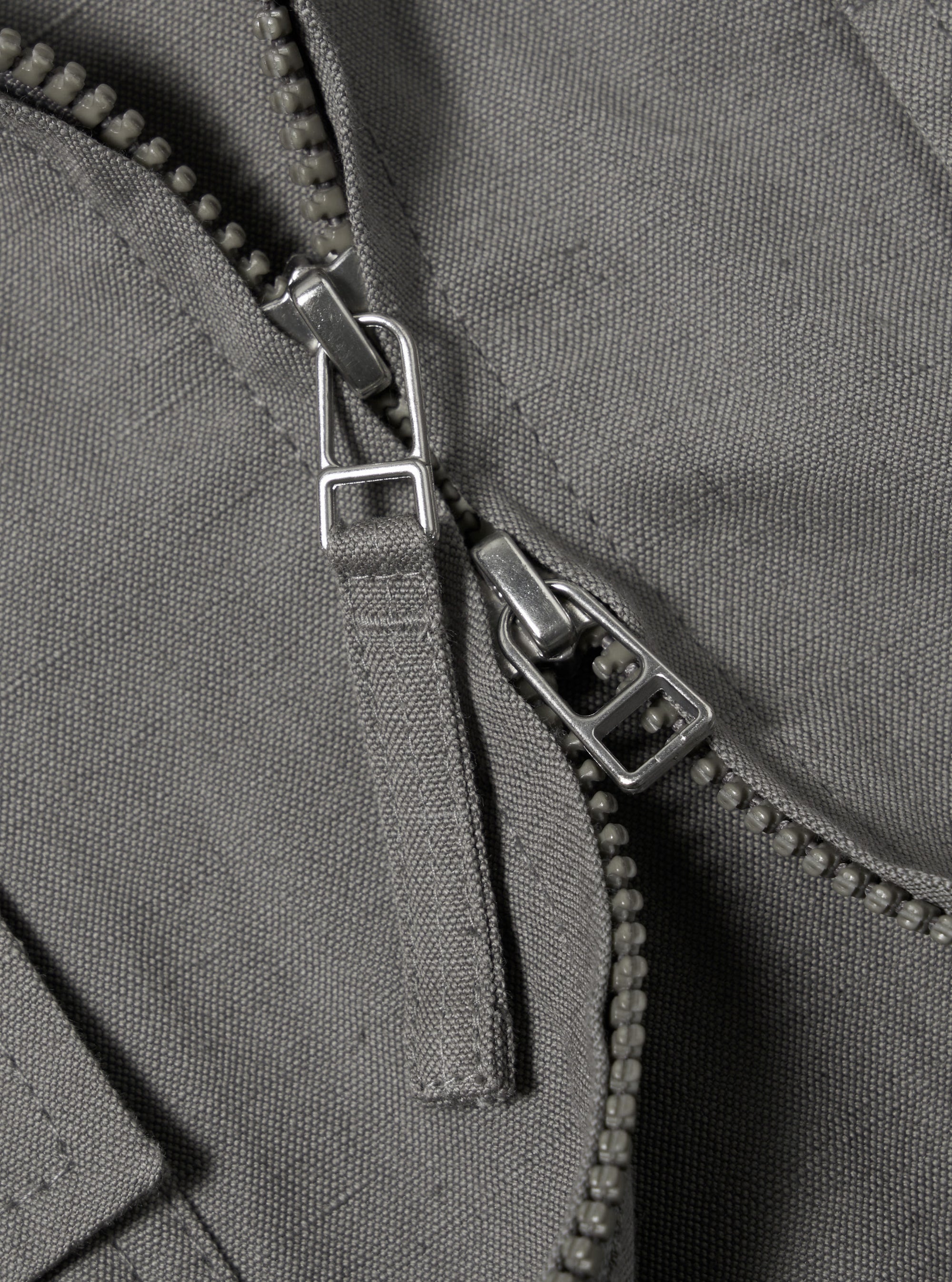 The Mid Grey Linen Slub Weave E130 Jacket is displayed from the back, laid flat against a solid white background. The image highlights the horizontal back yoke, the straight hem, and the textured slub weave of the grey linen fabric.