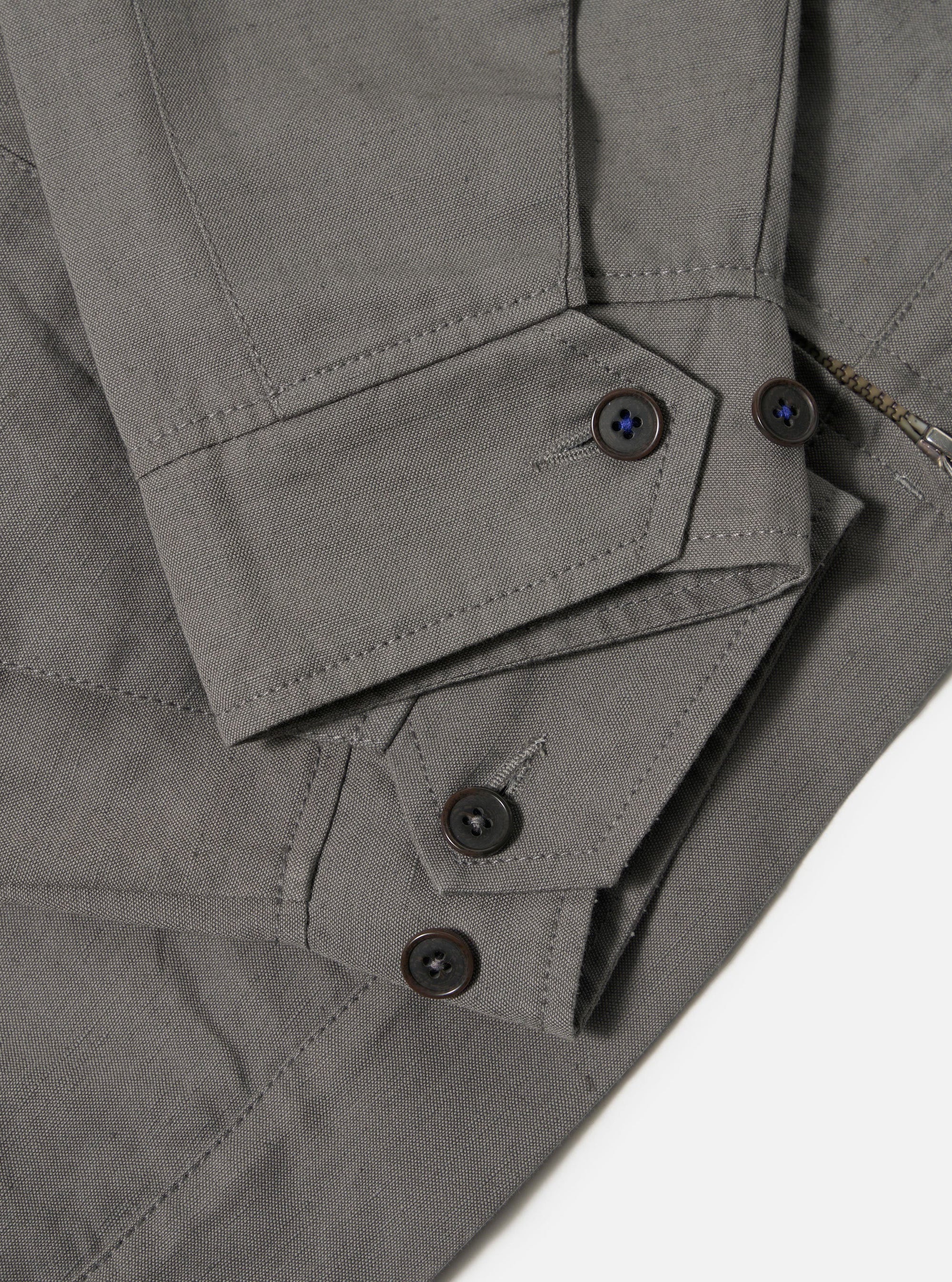 The Mid Grey Linen Slub Weave E130 Jacket is shown from the back, laid flat against a plain white background. The image highlights the textured, slubbed finish of the mid-grey linen-cotton fabric, featuring a straight hem and clean rear construction.