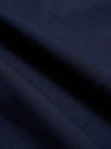 A close-up, square fabric swatch of the Navy Linen Slub Weave Dizzy Trouser highlights the material's deep navy blue color and intricate texture. The image shows a visible weave with characteristic irregular slubbed yarns, creating a subtle, natural variation across the surface of the cotton-linen blend.