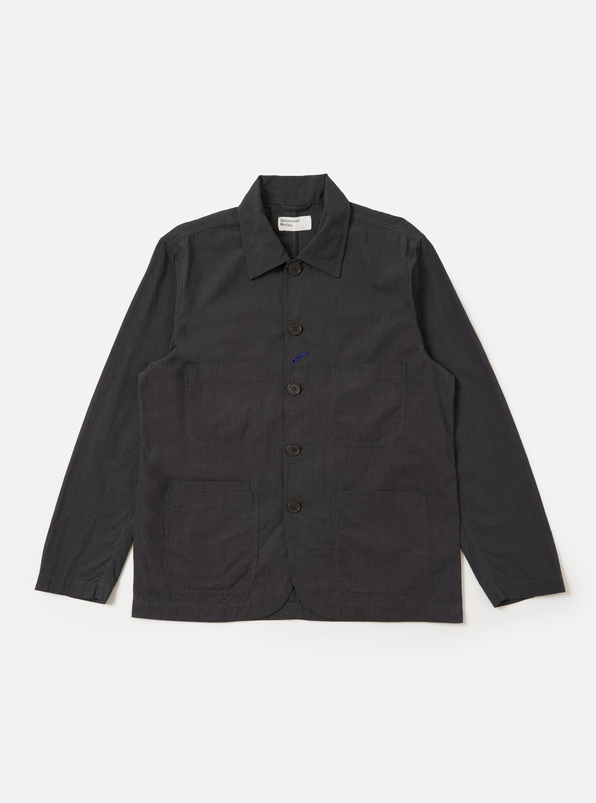 The Charcoal Seattle Cotton OG Bakers Jacket is shown laid flat against a solid white background. The charcoal grey jacket features a classic pointed collar, a five-button front closure, and four asymmetrical patch pockets on the front, including one chest pocket and one smaller internal-style pocket.