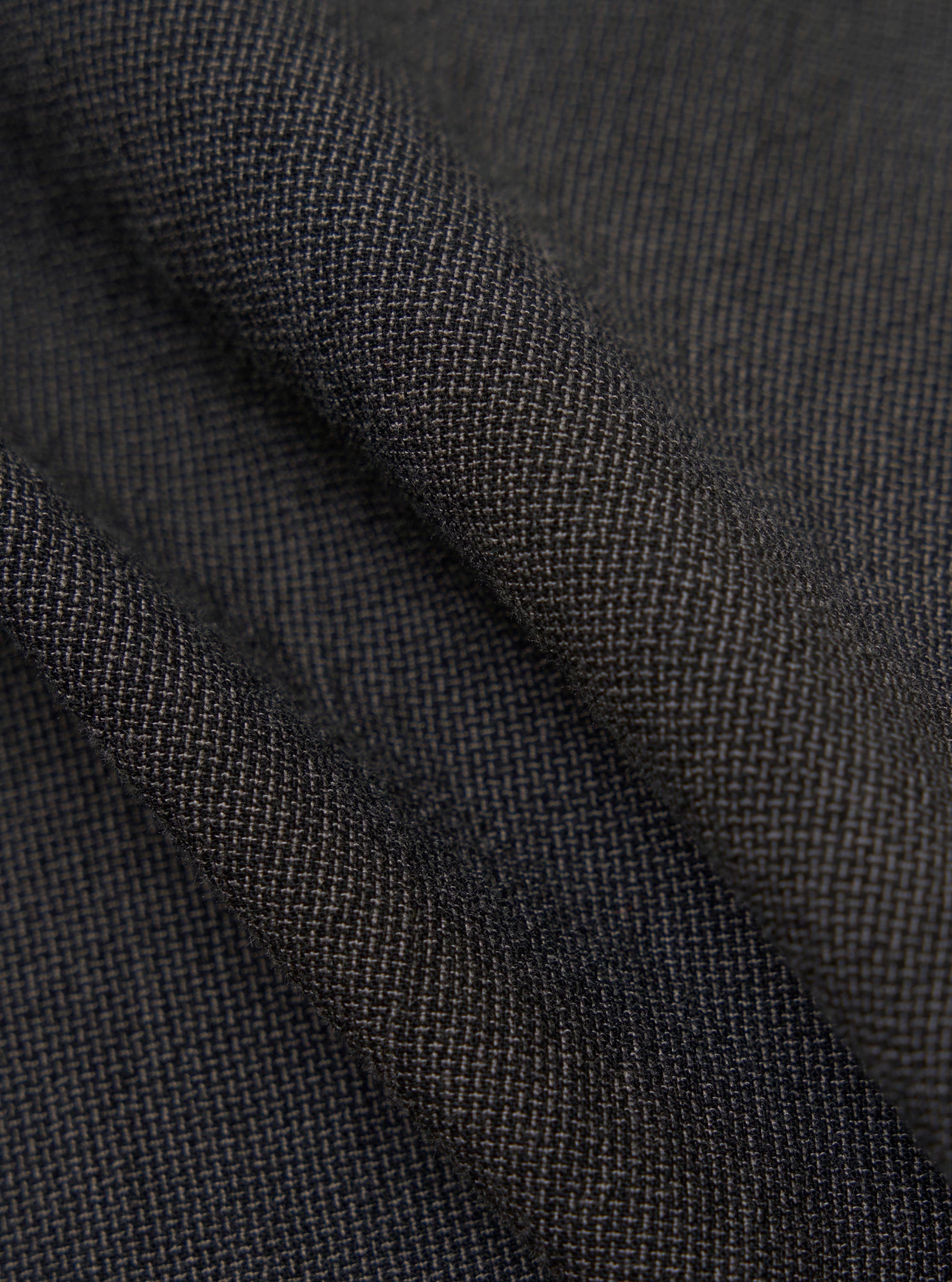 A close-up fabric swatch of the Charcoal Seattle Cotton Two Button Jacket highlights the intricate, two-color basket weave of the charcoal grey cotton material. The image focuses on the fine texture and interlaced threads of the fabric.