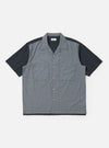The Mixed Check Plaid Camper Shirt is shown laid flat against a white background. The shirt features a camp collar, a button-down front, and a single chest pocket on the left side. The fabric has a patchwork-style plaid pattern in various shades of blue, navy, and white.