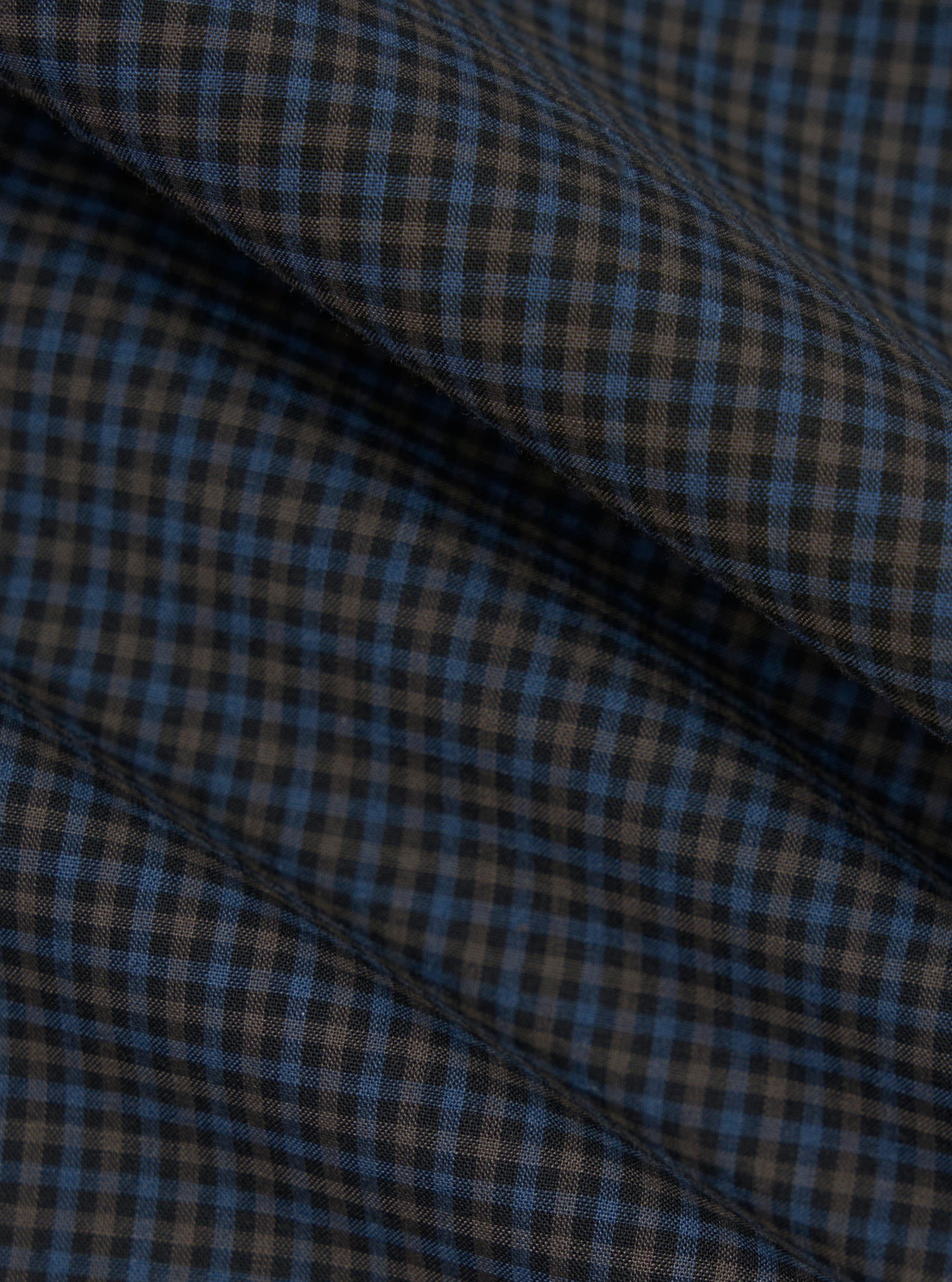 A close-up fabric swatch of the Mixed Check Plaid Camper Shirt features an intricate variety of intersecting check and plaid patterns in a multi-colored palette. The image focuses on the detailed texture and weave of the material.