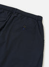 A rear view of the Navy Broadcloth Oxford Pant is displayed flat against a plain white background. The image highlights the waistband and a single rear buttoned flap pocket on the dark navy fabric.
