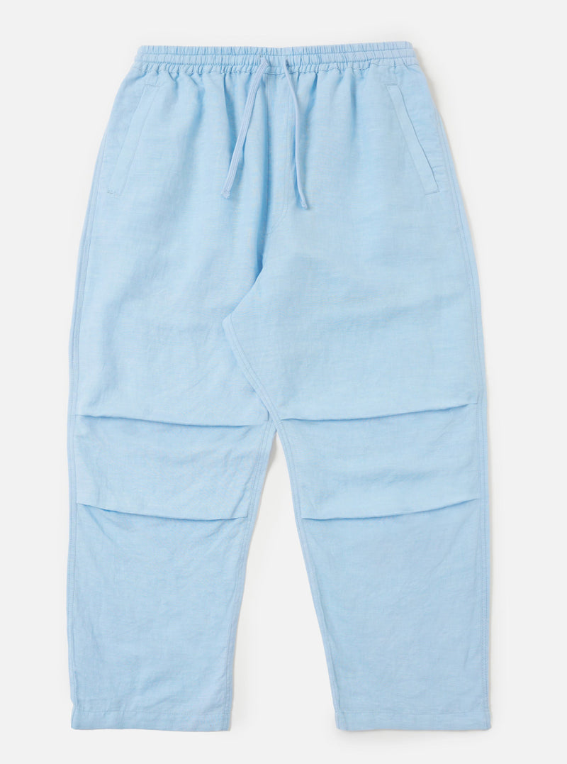 A pair of Pale Blue Linen Cotton Shirting Parachute Pants is displayed flat against a plain white background. The trousers feature a relaxed, straight-leg cut with a drawstring waistband and side slip pockets.