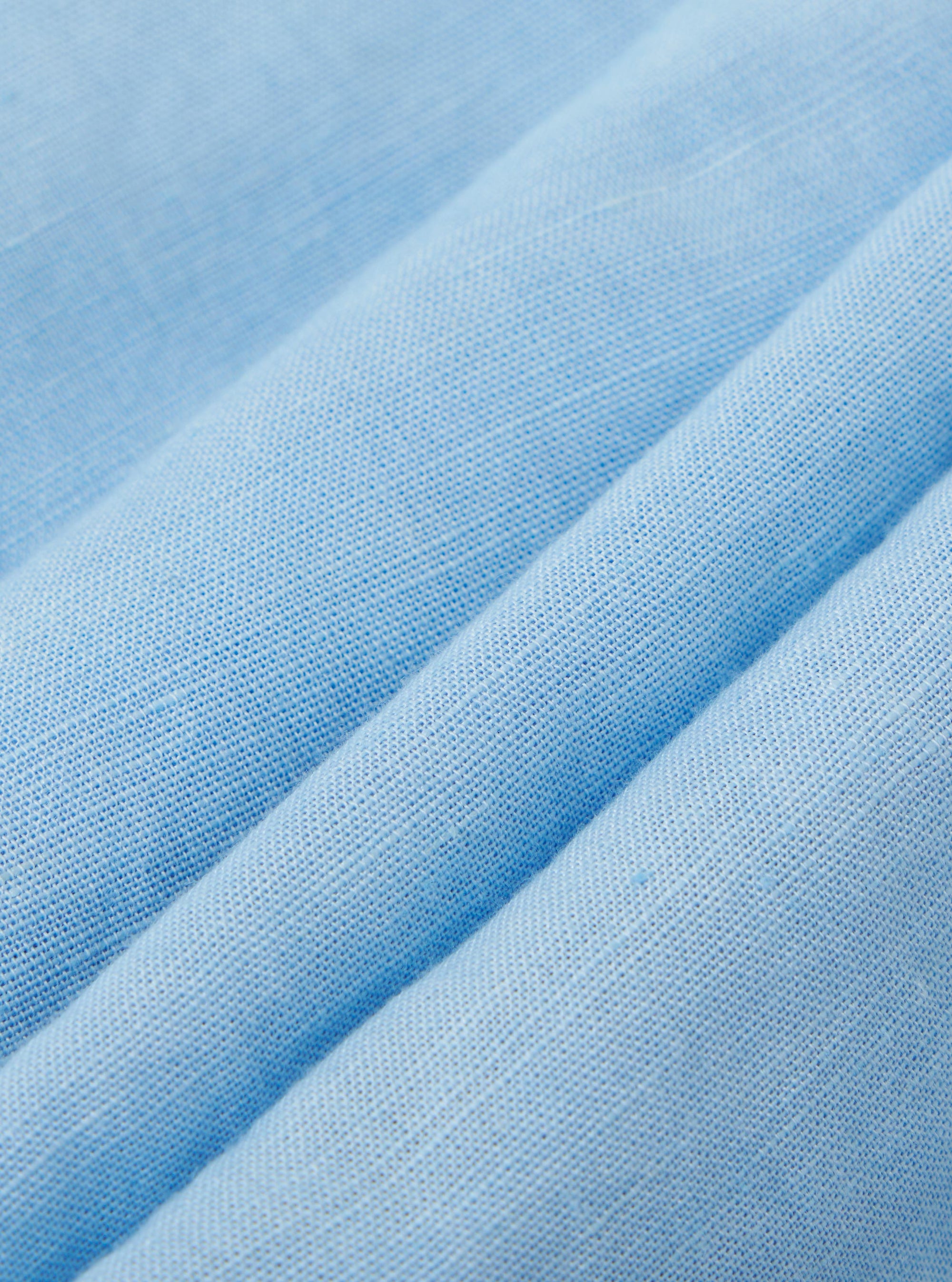 A detailed, close-up fabric swatch of the Pale Blue Linen Cotton Shirting Parachute Pant. The image highlights the fine weave and soft, light blue texture of the linen-cotton blend material.