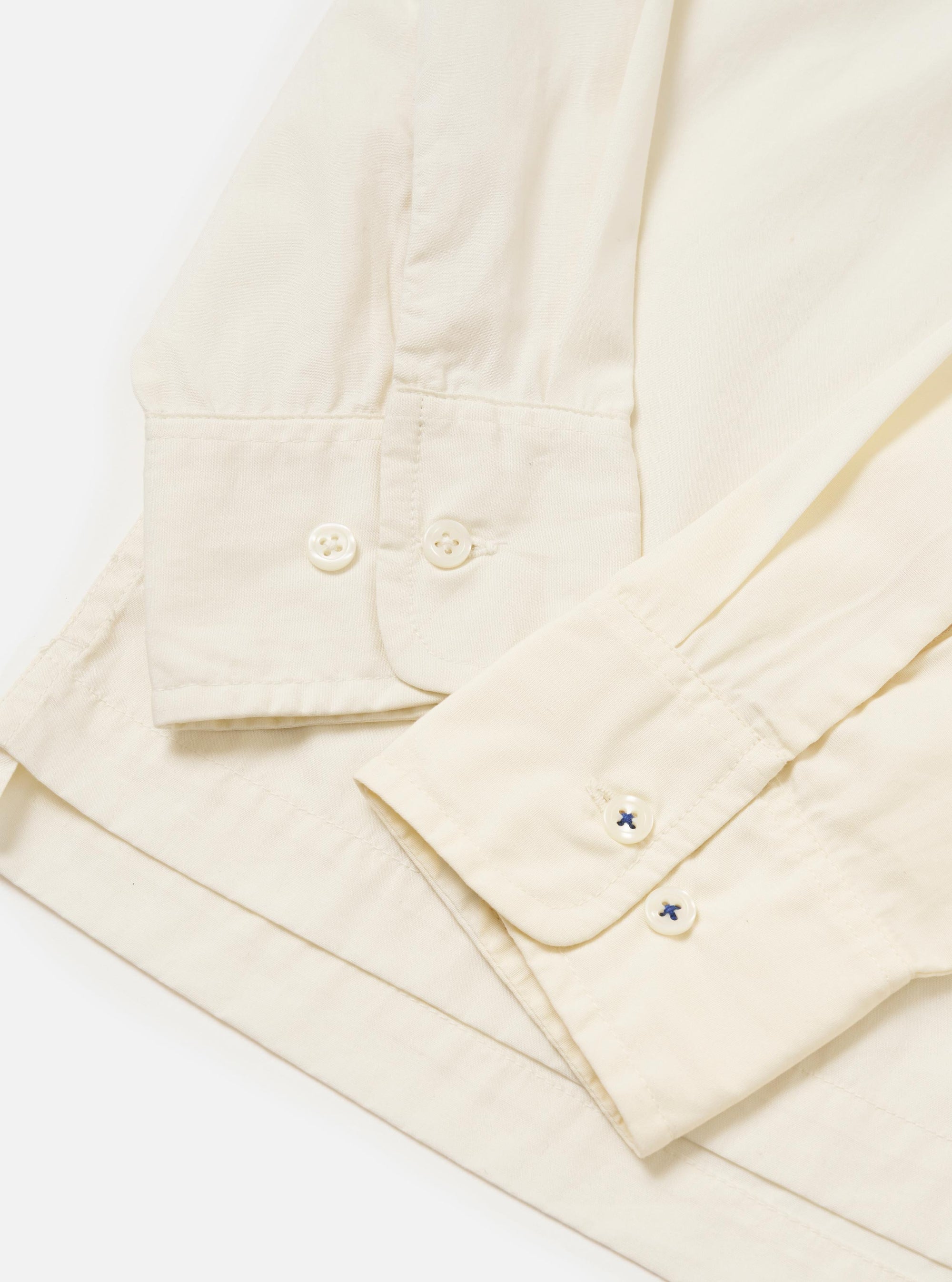 The Ecru Broadcloth Lucky Shirt is shown from a rear perspective, laid flat against a solid white background. The image highlights the horizontal back yoke and the clean, simple construction of the short-sleeved garment.