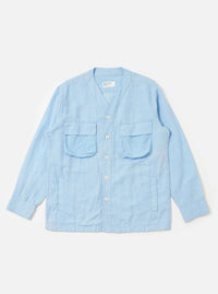 The Pale Blue Linen Cotton Shirting Parachute Shirt is displayed flat against a plain white background. This collarless, V-neck overshirt features a button-down front, two large 3D bellows pockets with buttoned flaps on the chest, and two vertical welt hand pockets near the waist. The garment is shown with long sleeves and a drawcord hem.
