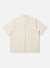 The Ecru Broadcloth Ewan Shirt is shown from the back, laid flat against a plain white background. The image highlights the short sleeves, a straight hem with side splits, a horizontal back yoke, and a central box pleat.