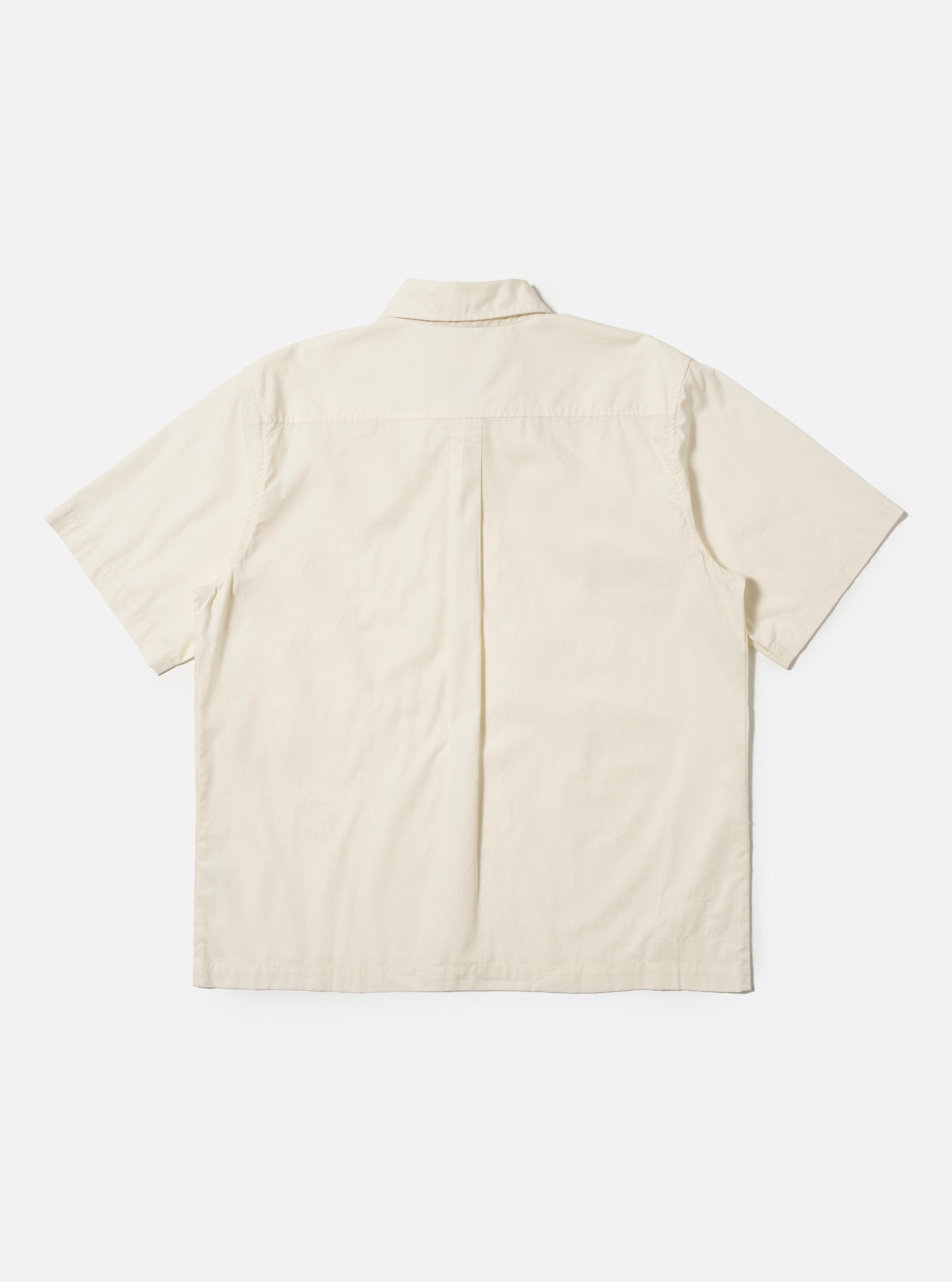 The Ecru Broadcloth Ewan Shirt is shown from the back, laid flat against a plain white background. The image highlights the short sleeves, a straight hem with side splits, a horizontal back yoke, and a central box pleat.
