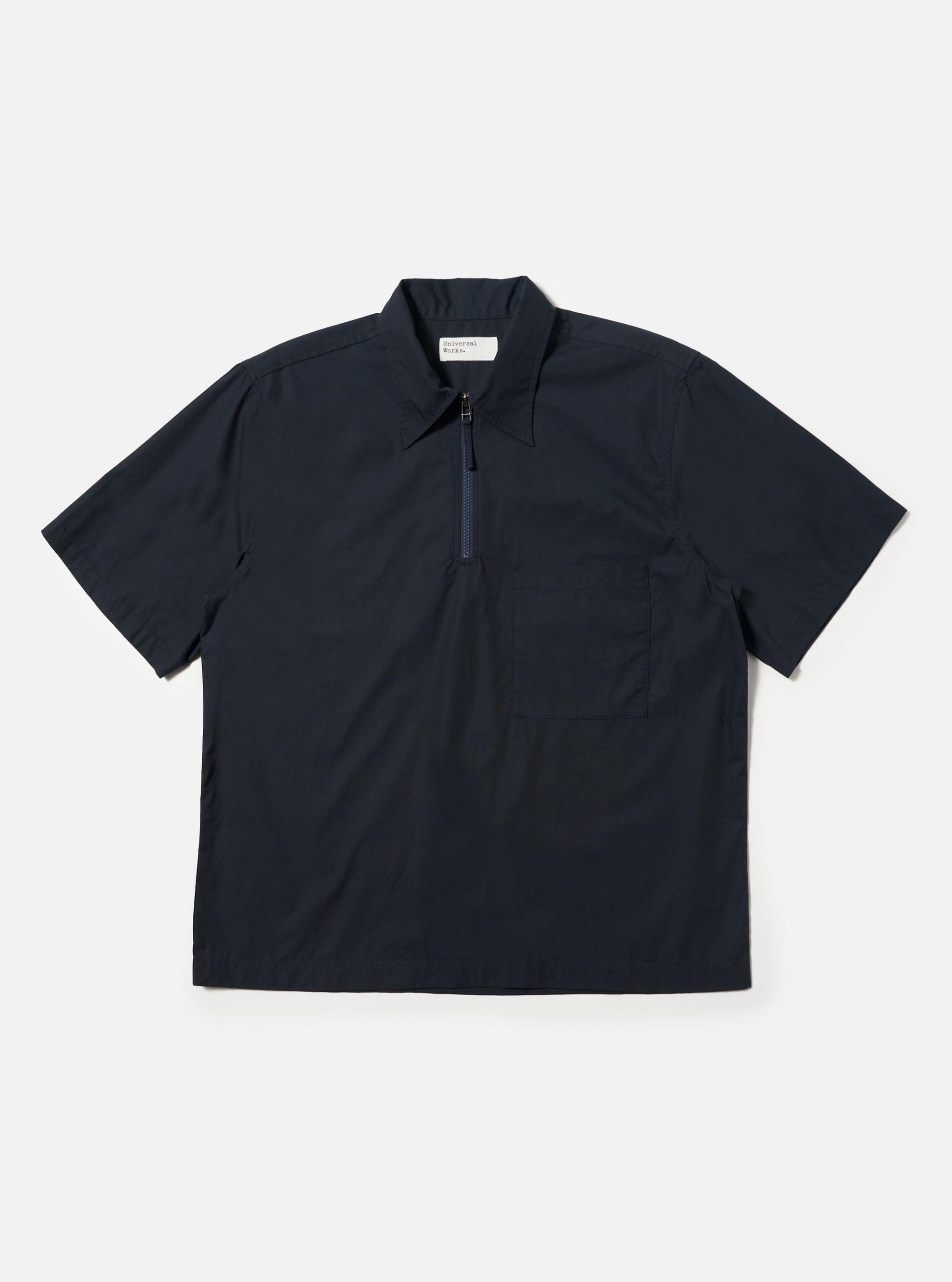 The Navy Broadcloth Ewan Shirt is shown laid flat against a solid white background. The navy blue pullover shirt features a classic pointed collar, a short quarter-zip at the neckline, and long sleeves.