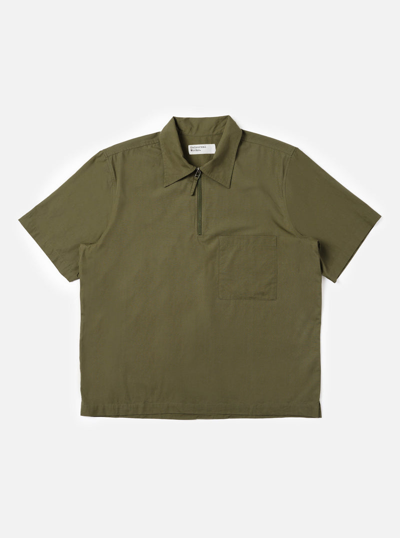 The Olive Broadcloth Ewan Shirt is displayed flat against a plain white background. The shirt features a relaxed, boxy fit with short sleeves, a classic pointed collar, and a distinctive quarter-zip neck closure. The smooth, solid olive green cotton fabric is the prominent feature.