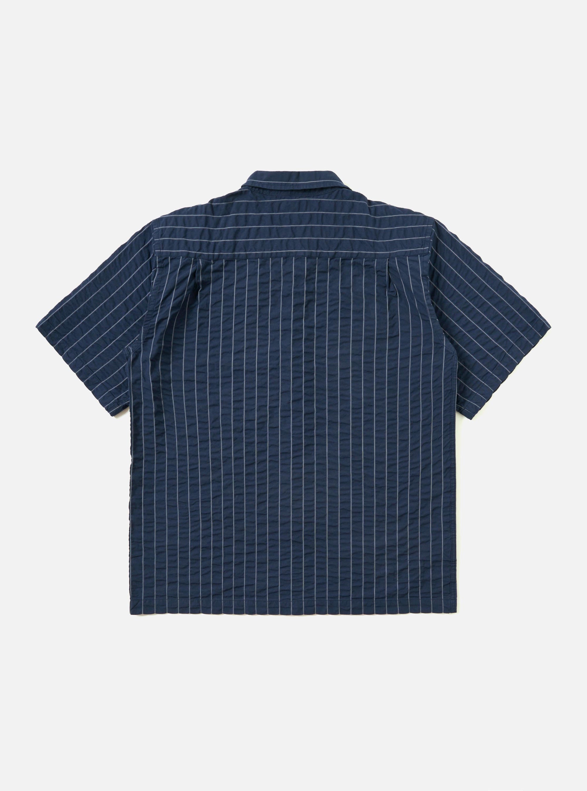 The Navy Chester Stripe S/S Fatigue Shirt is displayed flat against a plain white background. The shirt features short sleeves, a classic button-down front, and two prominent fatigue-style chest pockets with buttoned flaps. The fabric has a vertical navy and white stripe pattern.