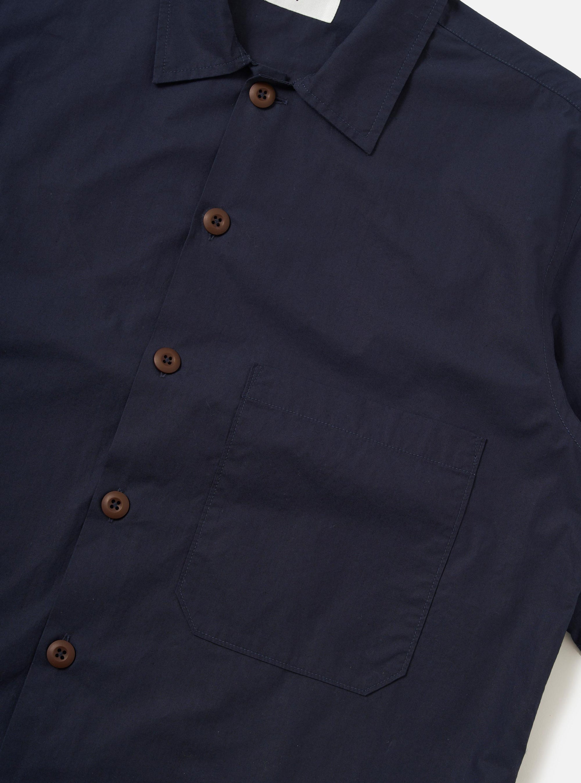 The Navy Paper Touch Cotton S/S Fatigue Shirt is shown from a rear perspective, laid flat against a plain white background. The image highlights the straight-cut hem, short sleeves, and a simple horizontal yoke across the shoulders.