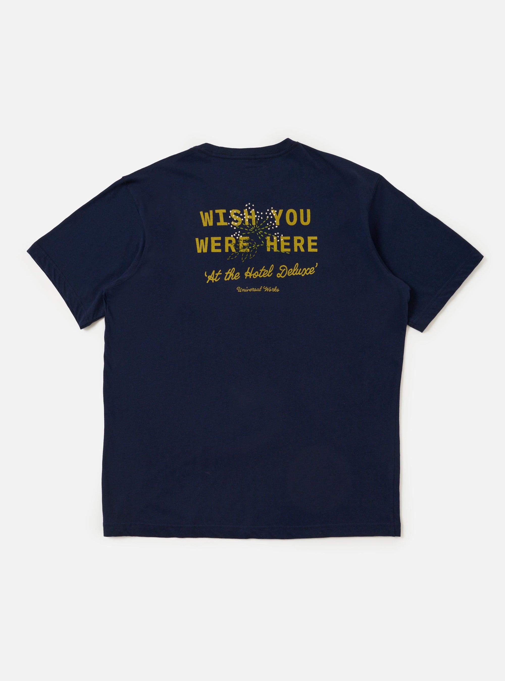 The Navy Single Jersey Wish Wish You Were Here Tee is shown from the back, laid flat against a plain white background. The image highlights the smooth navy blue cotton fabric and the clean, straight hem of the short-sleeved t-shirt.