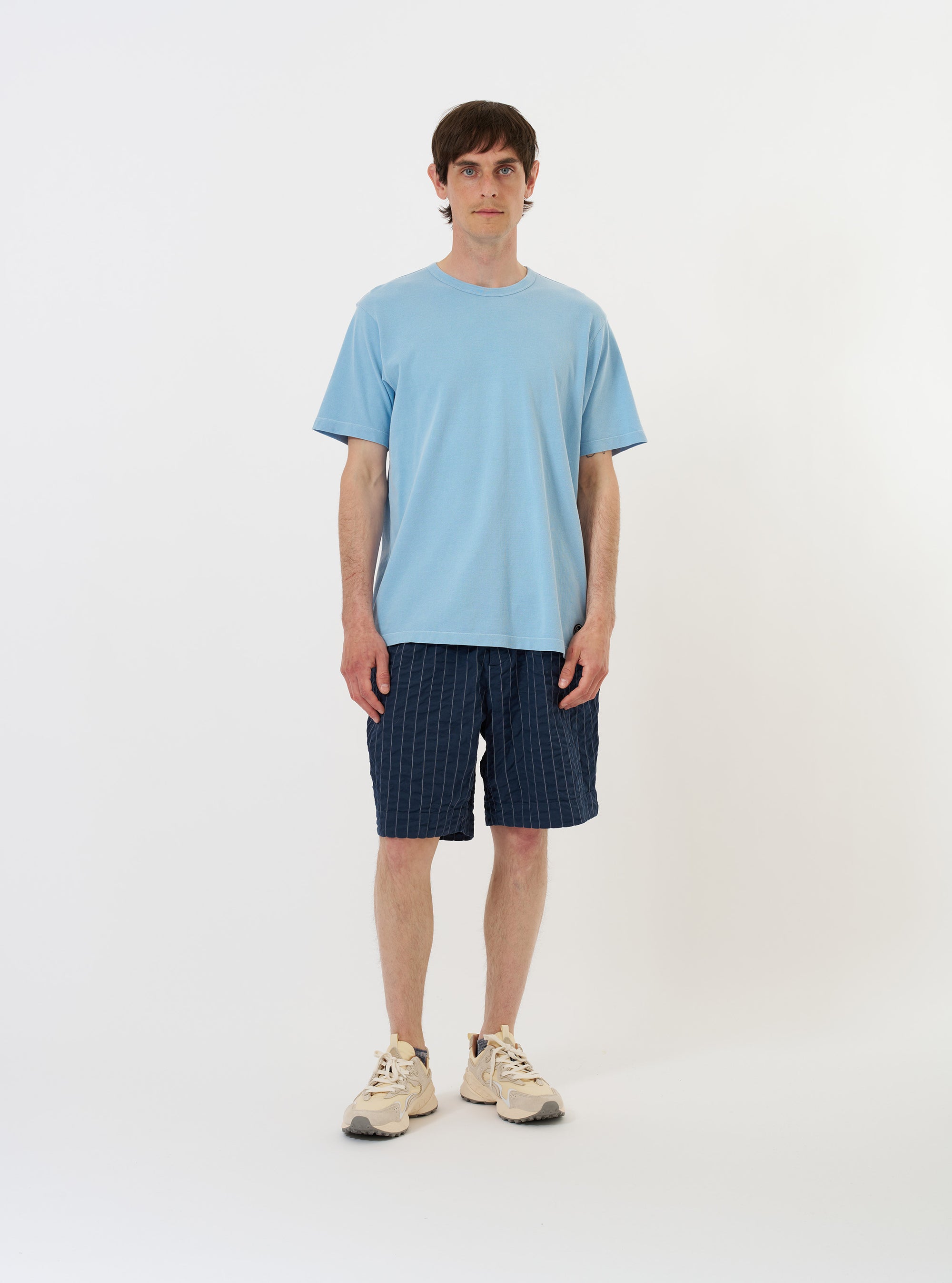 The Pale Blue Piquet Core Tee is displayed flat against a solid white background. The short-sleeve t-shirt features a simple, regular fit, a self-bound crew neckline, and a small woven brand label at the hem.