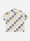 The back of the Pastel Check Patchwork Camp Shirt is shown laid flat against a plain white background. The garment features a patchwork construction of various pastel checked patterns in blue, navy, and ecru. Prominent details include the short sleeves, a straight hem, and a horizontal back yoke.
