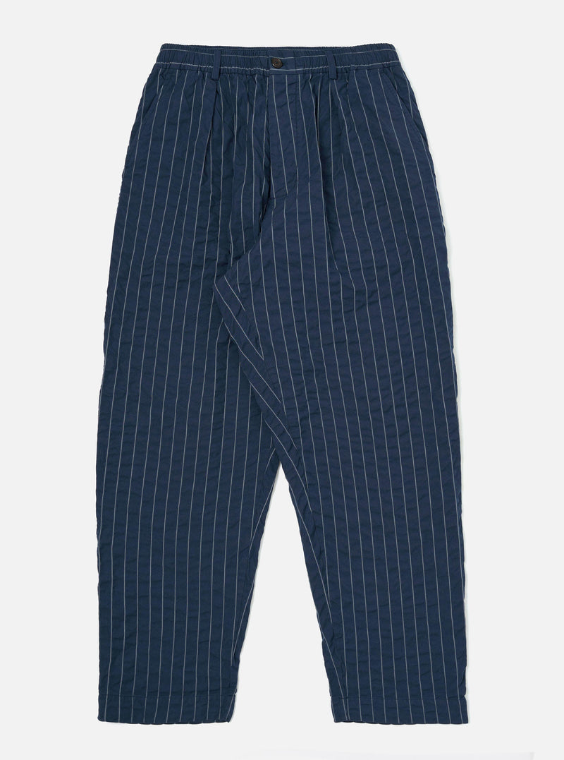 The Navy Chester Stripe Oxford Pant is displayed flat against a plain white background. The trousers feature a loose, wide-leg fit with vertical navy and white pinstripes, a drawstring waistband, and a single pleat in the front.