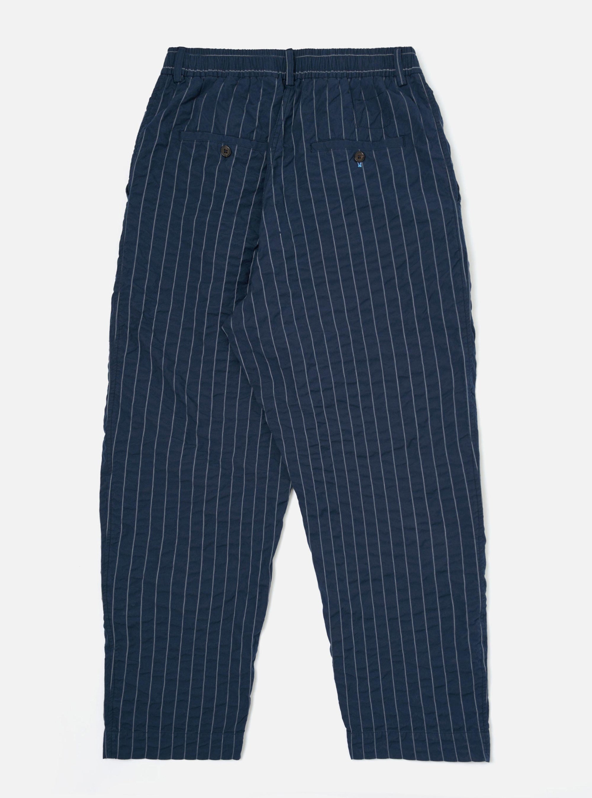 The back of the Navy Chester Stripe Oxford Pant is shown laid flat against a plain white background. The trousers feature a navy blue fabric with thin white vertical stripes, a wide-leg silhouette, and two rear patch pockets.