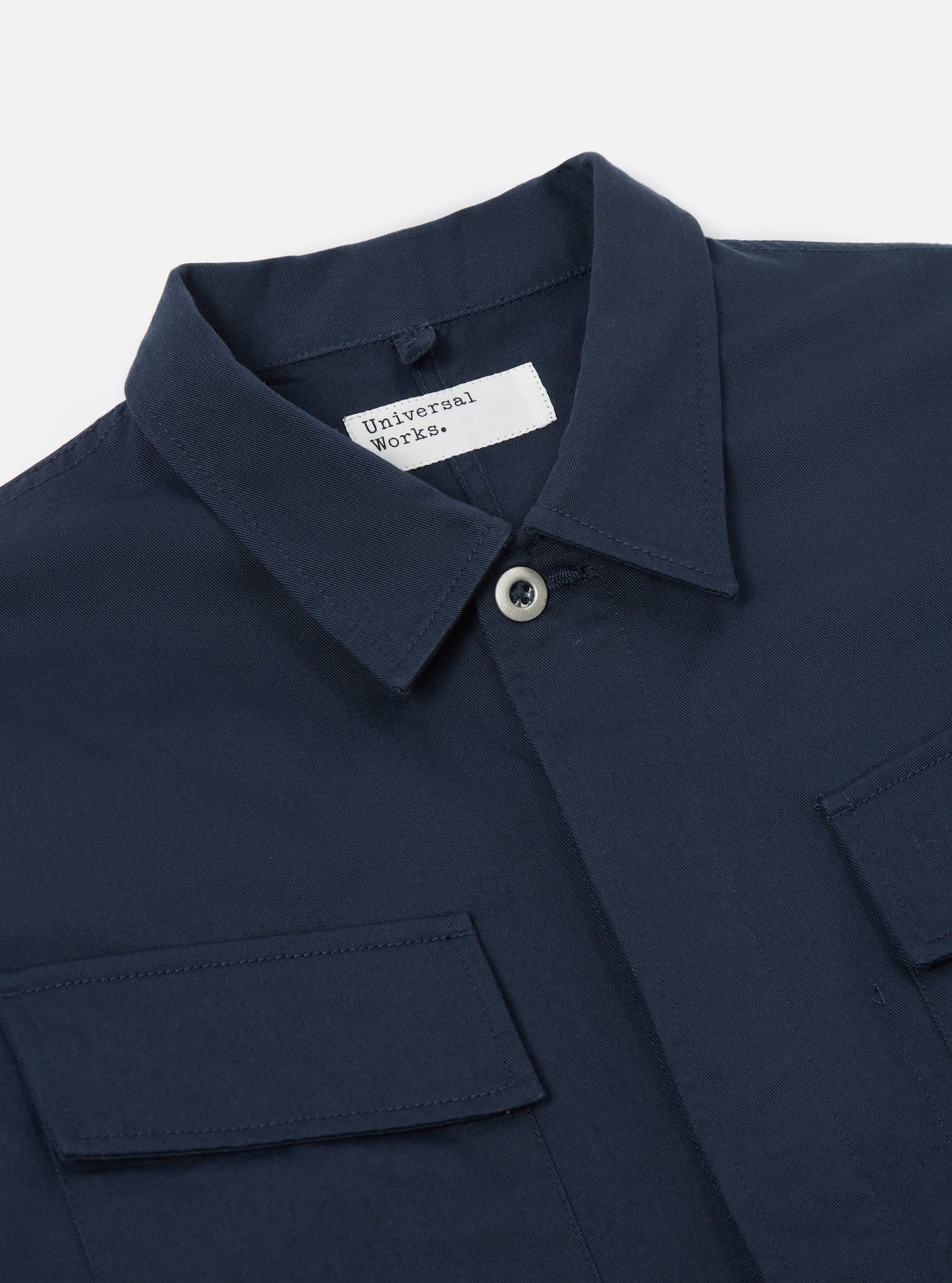Close-up of the Navy Twill MW Fatigue Jacket on a white background. The jacket features a twill texture, button closure, and chest pockets.