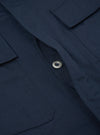 Close-up of the Navy Twill MW Fatigue Jacket showing the twill fabric, button, and pocket details. The jacket is laid flat on a neutral surface.