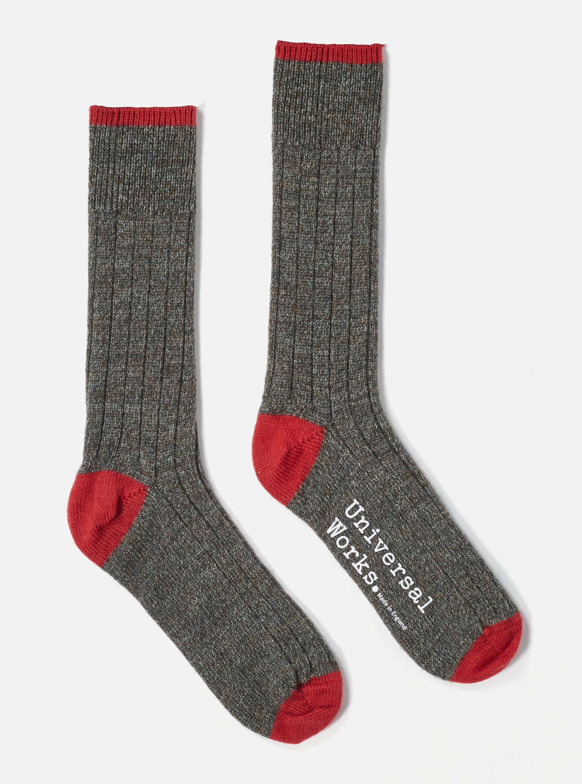 Two Derby Wool Hike Sock, displayed on a white background. The socks are gray with red toes and cuffs. One sock has "Universal Works. Made in England" printed on it.