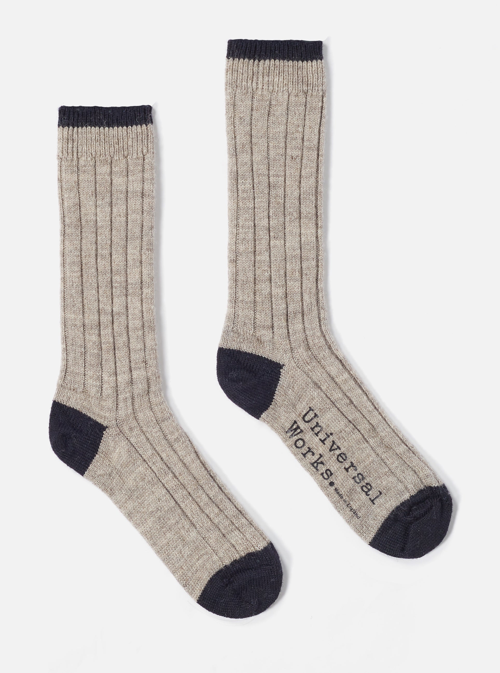 Two Stone Wool Hike Sock on a white background. The socks are ribbed and have a dark navy toe and top. The words "Universal Works" are printed on one sock.