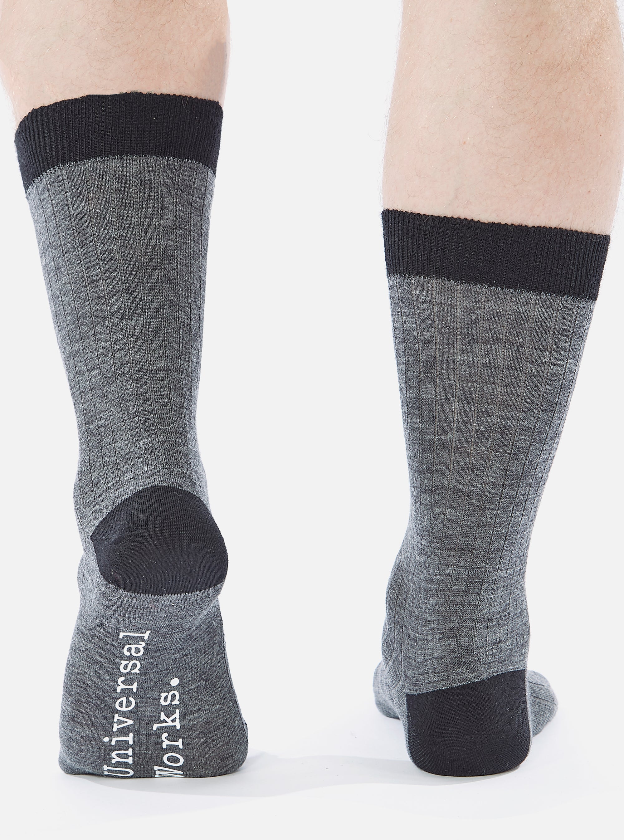 Close-up of a model wearing Grey Marl Merino Classic Sock, showcasing the ribbed texture and black accents on a white background.