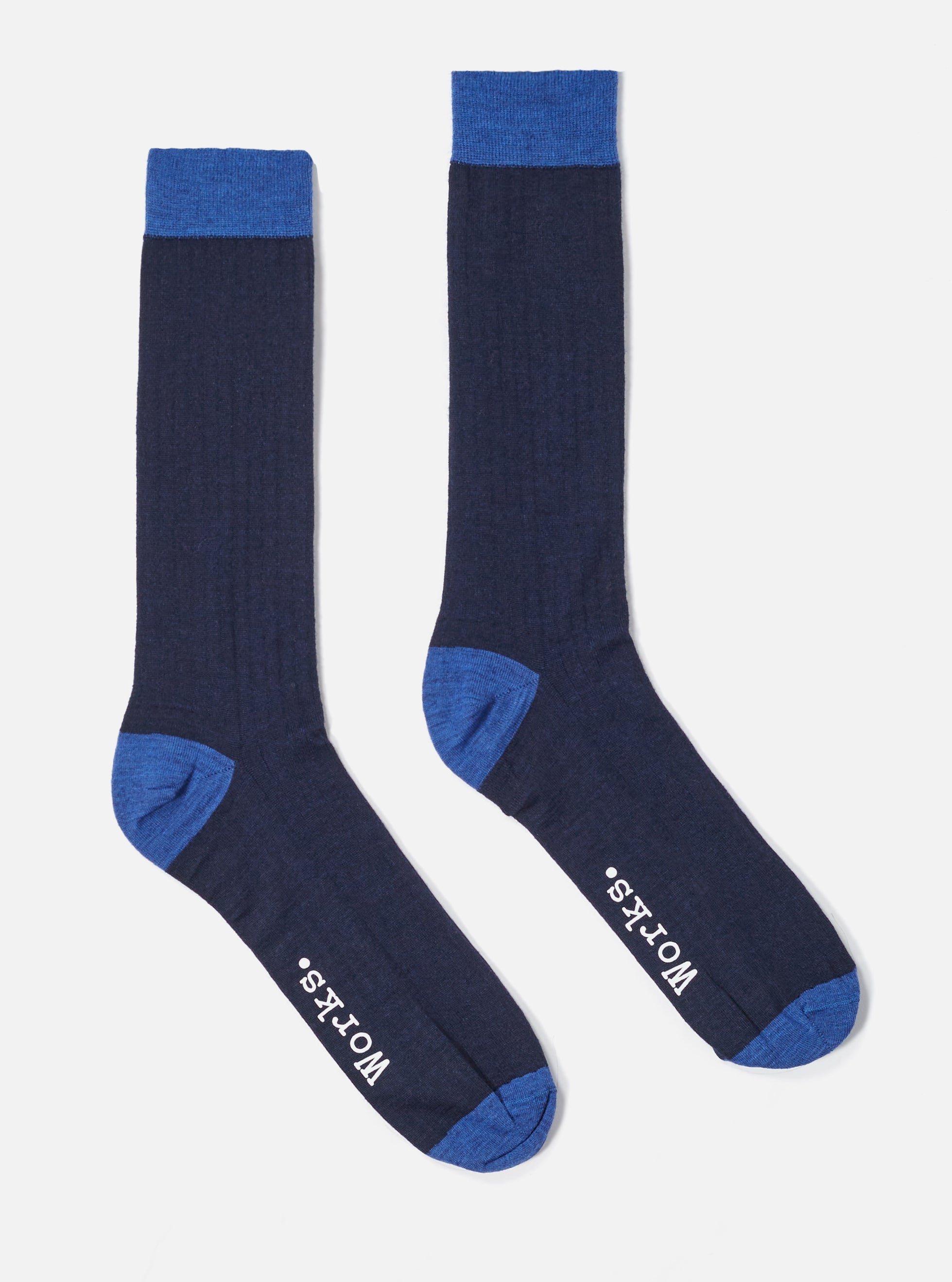 Studio shot of Navy Merino Classic Sock. The socks are navy with blue toe and top. Ribbed texture. White background.