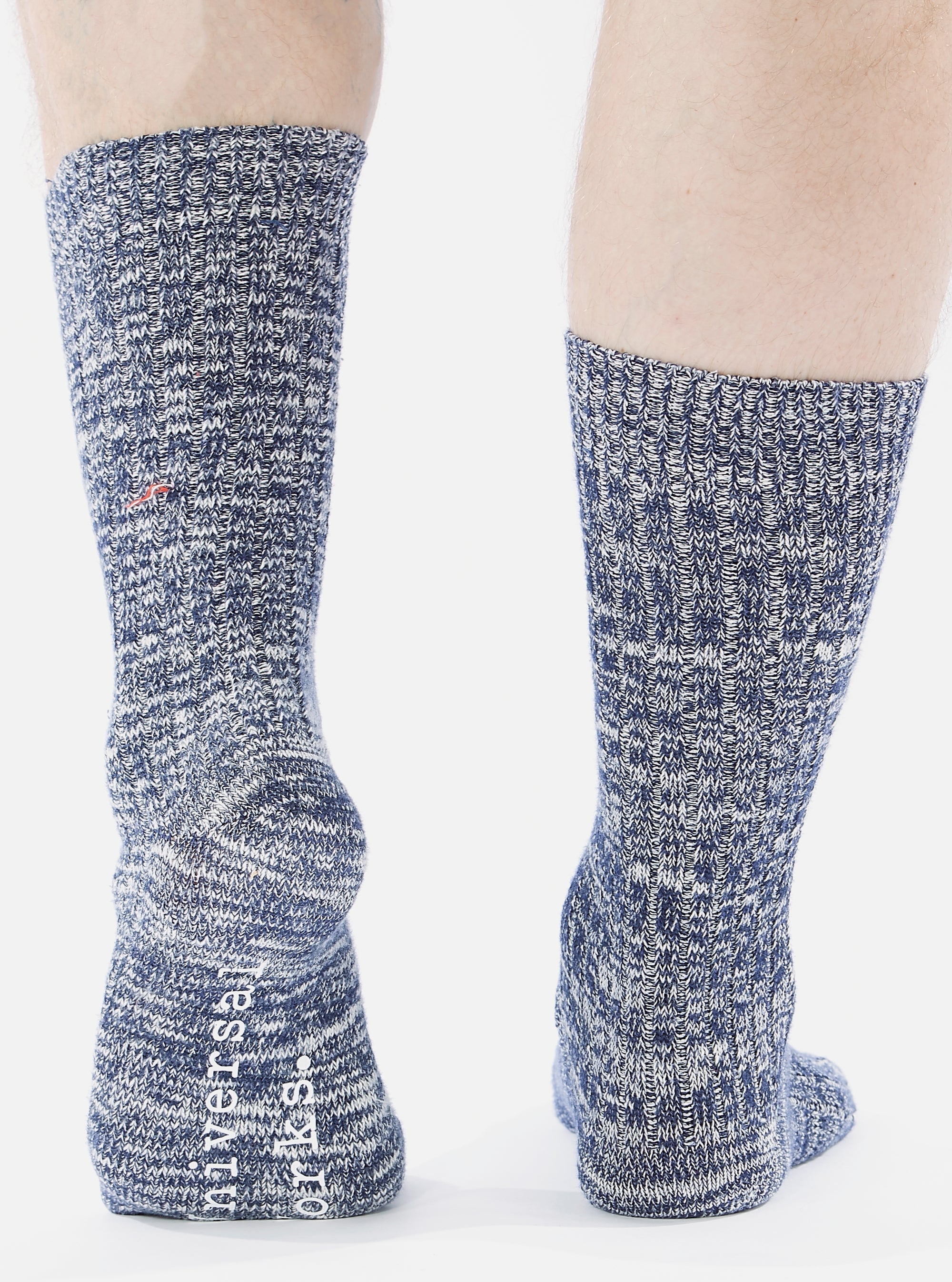 Close-up of a model wearing Navy Slub Knit Slub Socks. The socks are a textured navy and white knit. Shot on a white background.